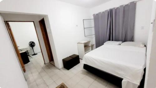 a bedroom with a white bed and a mirror at Casa Aeroporto a poucos minutos do Aeroporto de Viracopos in Campinas