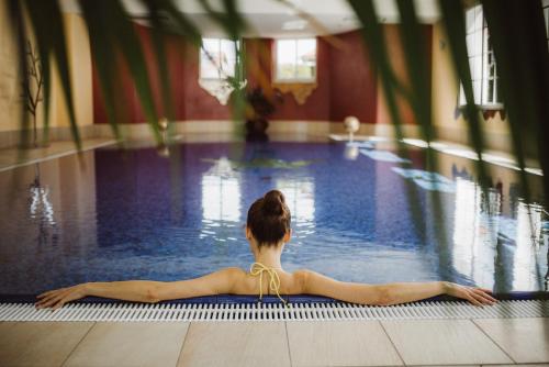 a woman swimming in a swimming pool at Gesundheitshotel König in Grünenbach