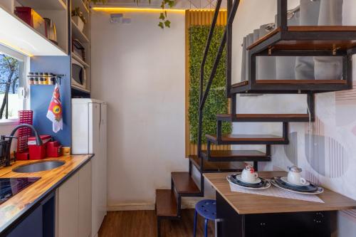 a kitchen with a sink and a counter with a table at Minicasa Brasileira in Sorocaba