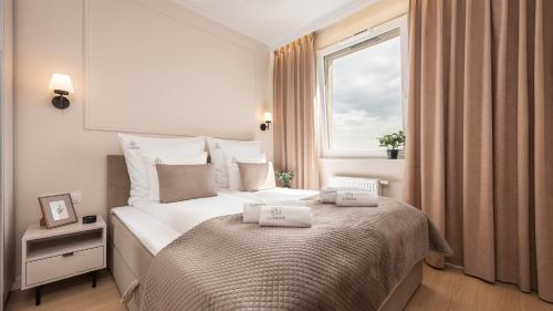 ein Schlafzimmer mit einem Bett mit zwei Handtüchern darauf in der Unterkunft Flatbook - Seaside Apartments Nowa Letnica with a Rooftop Viewing Terrace & Gym II in Danzig