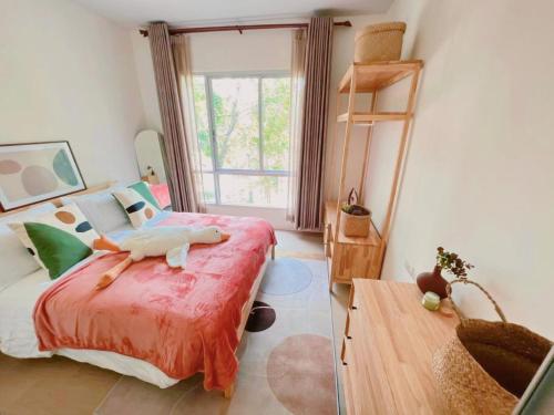 a bedroom with a bed with a bird laying on it at Minimalist Oasis - Monthly Stay Near Airport, Local Gems & Mall - Minimum Stay 28 Days in Bangkok