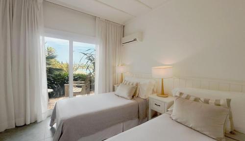 a hotel room with two beds and a window at Terrazas Al Mar in Pinamar