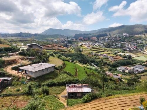 eine Luftansicht eines kleinen Dorfes in den Hügeln in der Unterkunft Nuwara eliya rashini mountain view cottage in Nuwara Eliya