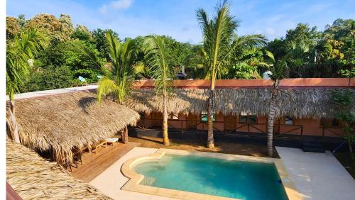 a resort with a swimming pool and palm trees at Casa Antonio Mazunte in Mazunte
