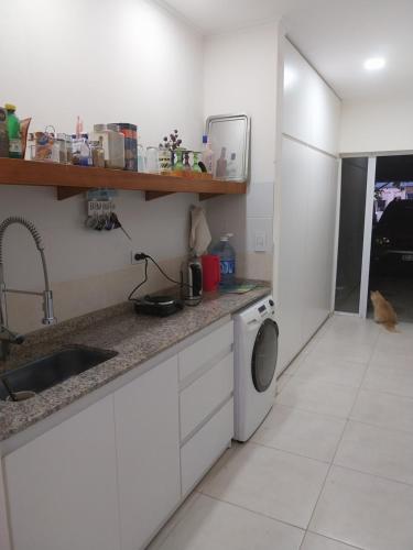 a kitchen with a sink and a washing machine at Felicità in Realicó