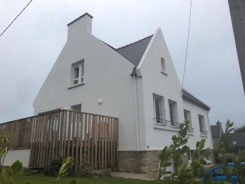 una casa bianca con una recinzione davanti di Menbleis, maison familiale a Plounéour-Trez