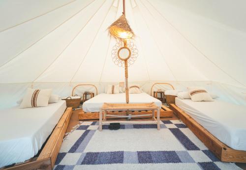 メキネンサにあるTres Estrellas Mequinenzaのベッド2台とテーブル付きのテントが備わる客室です。