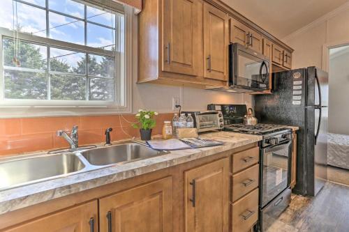 eine Küche mit Holzschränken und einer Spüle aus Edelstahl in der Unterkunft Dosanko Cottage & Suites at Equestrian House PA in Pleasant Mount