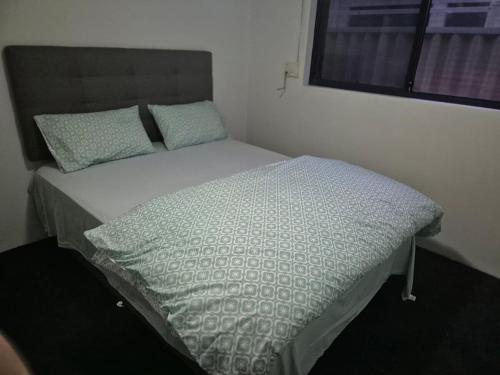 a bed in a small room with avertisement at Dalyellup 2BR accommodation-Rear Guest house Unit- Walkable to major supermarkets in Bunbury