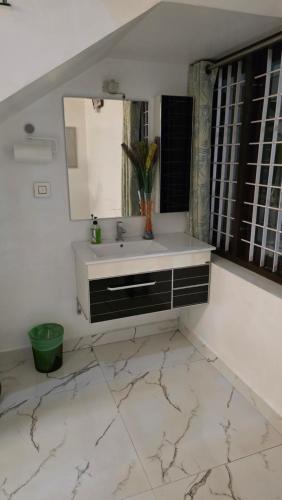 RāmamangalamにあるGolden Nestの洗面台と鏡のあるバスルーム