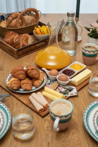 una mesa con alimentos para el desayuno y una jarra de zumo en Houseloft Metropolis Panorama, en Tesalónica