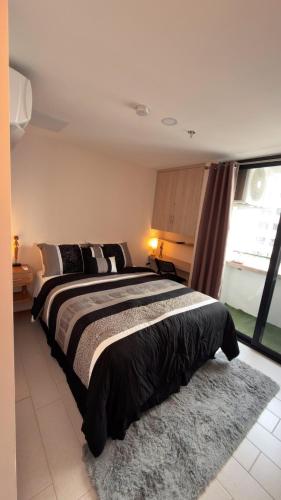 1 dormitorio con 1 cama grande con alfombra en Moderno apartamento en Lirios de Miraflores, en Tegucigalpa