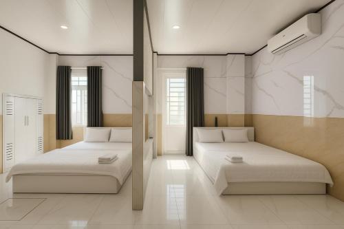 Dos camas en una habitación con paredes blancas. en CKC Motel - Near Can Tho City Center, en Can Tho