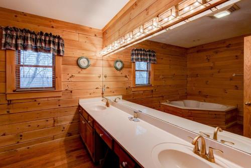 a bathroom with a tub and a sink and a bath tub at Atop Boone in Boone