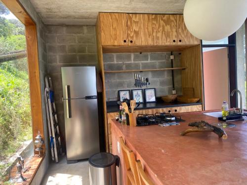 una cucina con frigorifero in acciaio inossidabile e bancone di Refúgio Contemporâneo na Serra da Bocaina a Silveiras