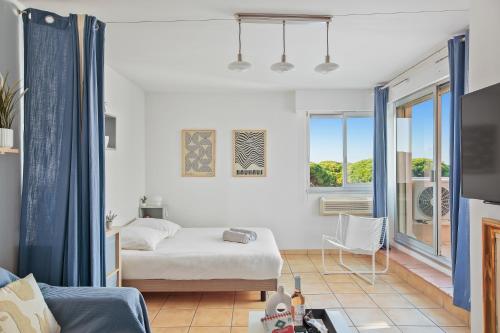 ein weißes Schlafzimmer mit Bett und Balkon in der Unterkunft Piscine & Soleil à Hyères - T3 spacieux avec Clim & Extérieurs in Hyères