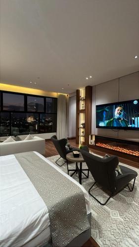 a bedroom with a large bed and a flat screen tv at فندق ريونيون للأجنحة الفندقية - Reunion Hotel Abha in Abha