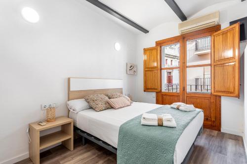a small bedroom with a bed and a window at Viviaro Peixcateria in Sagunto