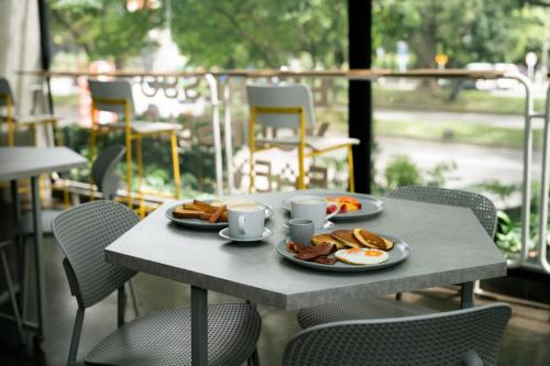 a table with two plates of eggs and toast at Indie Universe Creative Hotel in Medellín