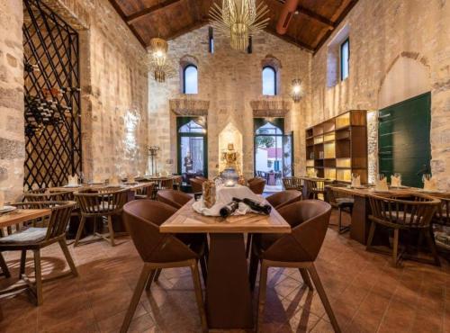 a dining room with tables and chairs in a building at Historic Han Hideaway in Vrana