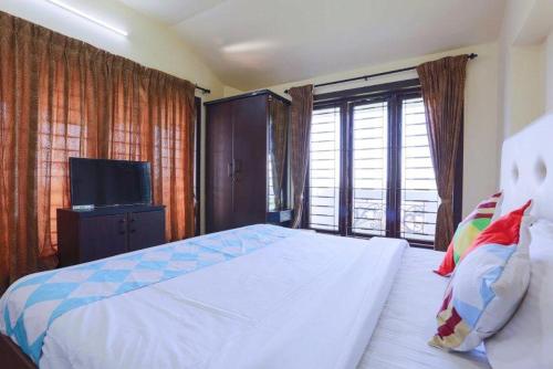 a bedroom with a large bed and a television at Krishna residency in Ooty