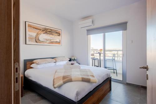 a bedroom with a bed and a balcony at TelMar Sky View in Larnaca