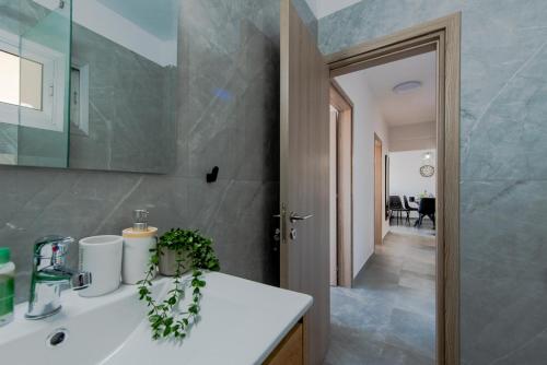a bathroom with a sink and a mirror at TelMar Sky View in Larnaca