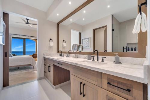 a bathroom with two sinks and a large mirror at Oceanfront Infinity Pool Vera Neo Beach Club Gym in San José del Cabo