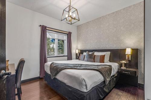 a bedroom with a large bed and a window at Amazing Views 1BR Condo with Hot Tub and Pool in Canmore