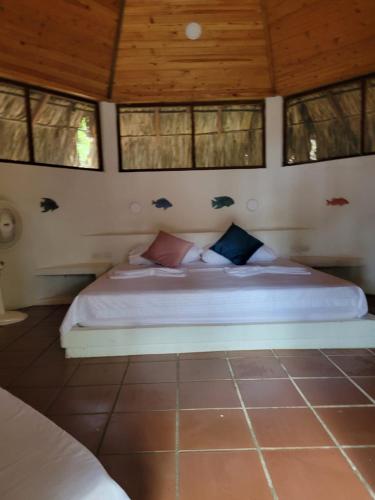 a bedroom with a bed with birds on the wall at Ecohotel Nativa Beach in Cartagena de Indias