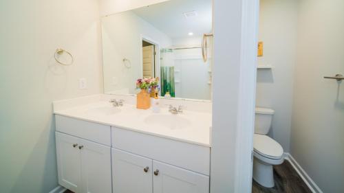 a white bathroom with a sink and a toilet at Golf and Beach Getaway in Sunset Beach