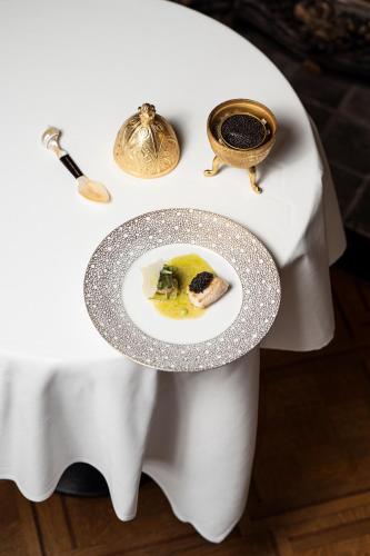 a white table with a plate of food on it at Kasteel van Ordingen in Sint-Truiden