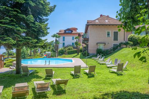 a group of chairs and a swimming pool in front of a house at Villa Anna Isole Borromee in Baveno