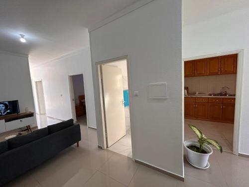 a living room with a couch and a door to a kitchen at Sun & Sea Tarrafal in Tarrafal