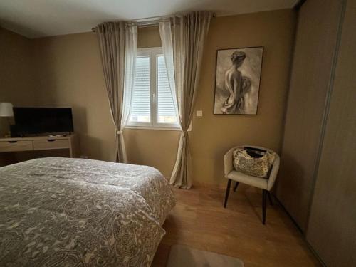 a bedroom with a bed and a chair and a window at Maison neuve in Berson