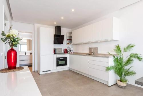 a kitchen with white cabinets and a red vase at Costa del Sol with proximity to the sea and golf in Sitio de Calahonda