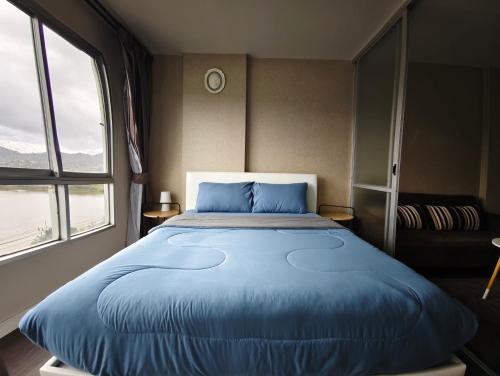 a large blue bed in a room with a window at D Condo mine Kathu in Kathu