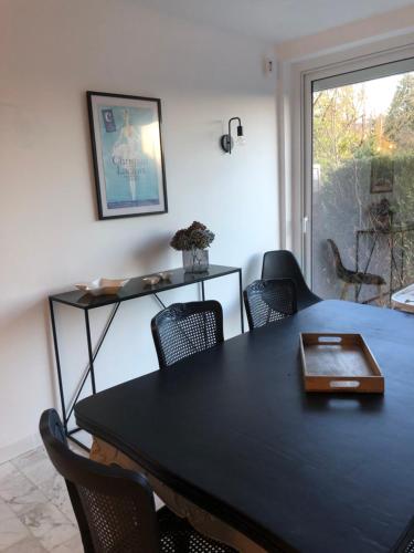 une salle à manger avec une table et des chaises noires dans l'établissement La Suite 81, à Yzeure