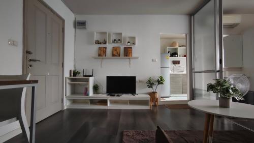 a living room with a television and a table at D Condo mine Kathu in Kathu