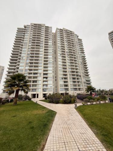 ein großes Wohnhaus mit einer Palme davor in der Unterkunft Depto Peñuelas in Coquimbo