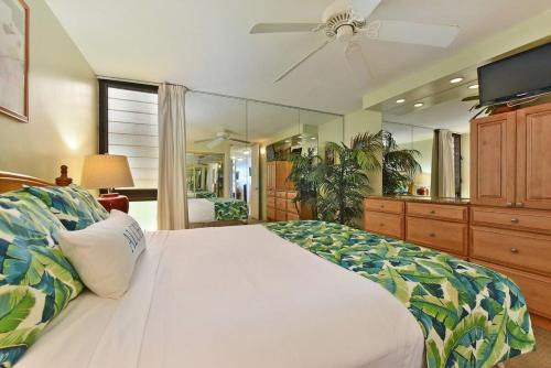 a bedroom with a large bed with a ceiling fan at Kaleialoha 211 · KA 211 OceanFront 1BD Whale Watch Relax Getaway in Kahana