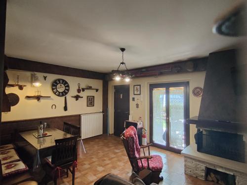 een woonkamer met een tafel en een klok aan de muur bij La Baita di Vincenzo in Castel di Sangro