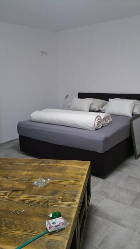 łóżko w pokoju obok stołu w obiekcie Opatment - die Nussschale w mieście Mörbisch am See