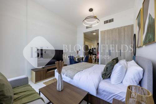 Un dormitorio con una cama, un sofá y una mesa. en Bloomfields EcoGate Stu Masdar City, en Abu Dhabi Intl