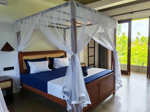 a bedroom with a bed with a canopy at Amarante Madiha in Matara