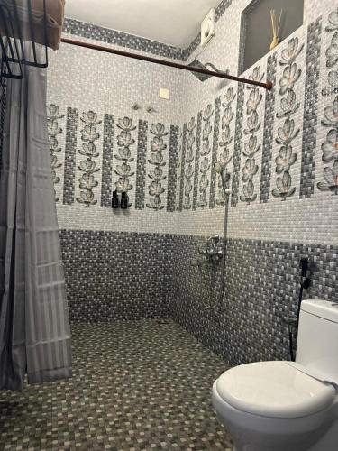 a bathroom with a toilet and a shower at 4elementis beach homestay in Mararikulam