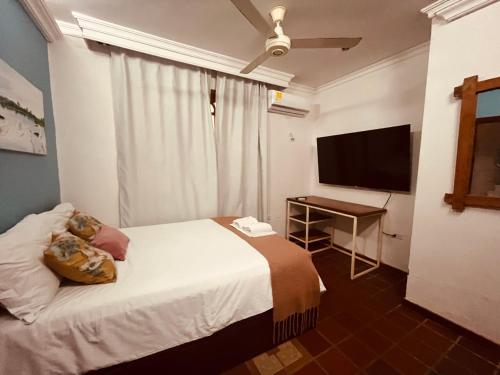 a hotel room with a bed and a television at Casa Isabelita in Mompos