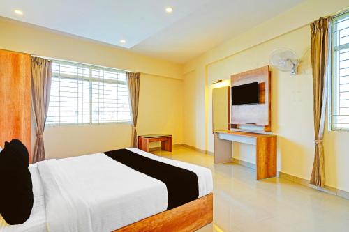 a bedroom with a bed and a television in it at Hotel O Indian Suites in Bengaluru