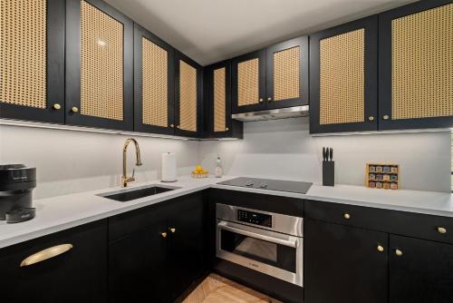 a kitchen with black cabinets and a sink at Freeman 303 by Rove - 1BR Condo with Shared Amenities in New York