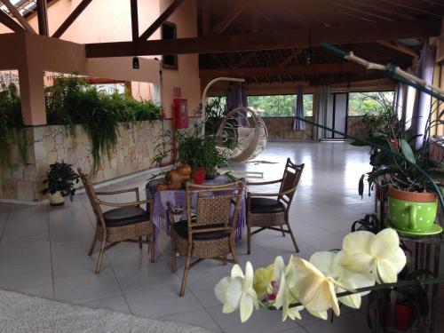 a patio with a table and chairs and plants at Pousada Canto das Corujas in São Roque